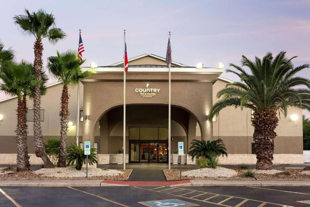 a shopping center with palm trees in a parking lot at Country Inn & Suites by Radisson, Lackland AFB San Antonio , TX in San Antonio