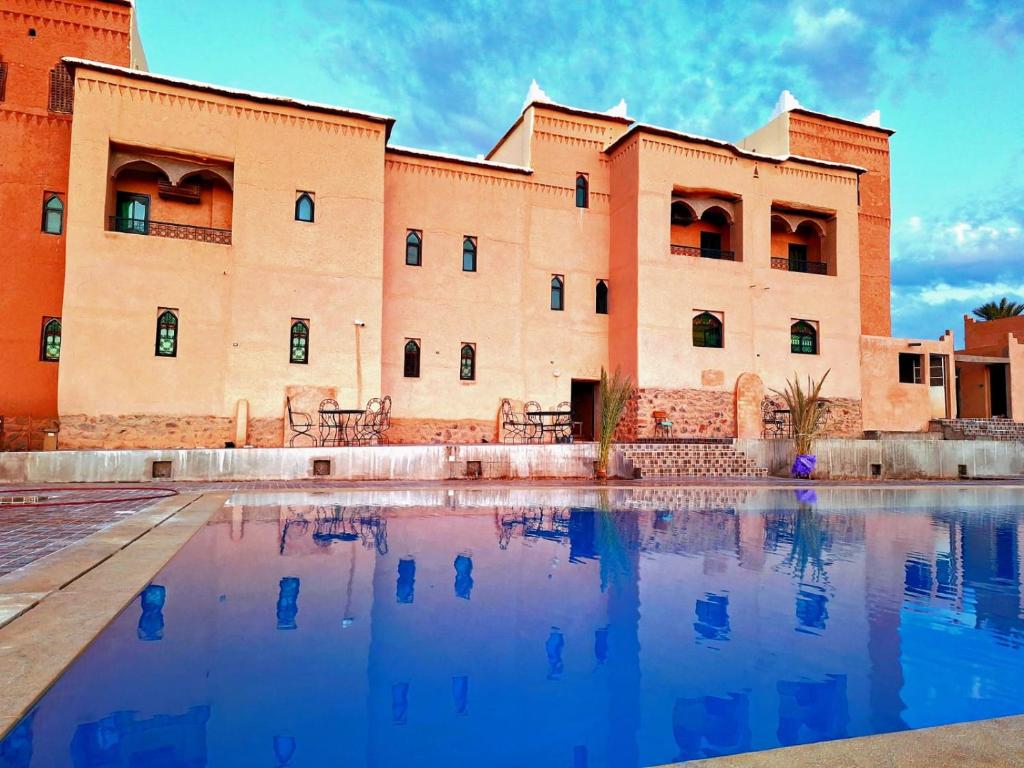 a building with a pool in front of it at Kasbah Zitoune in Ouarzazate