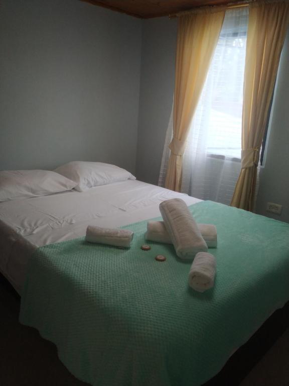 uma cama com toalhas e uma janela em Hostal El Balcon de madera em Norcasia