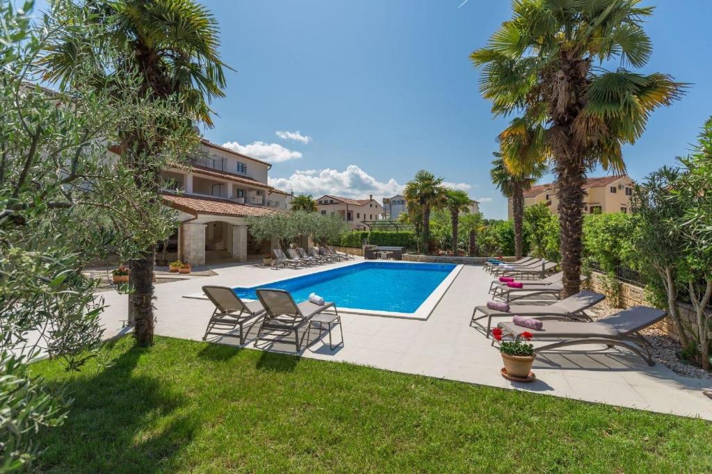 Villa con piscina y palmeras en Ferienwohnung Paradiso 3 für 2 Personen mit Pool, en Poreč