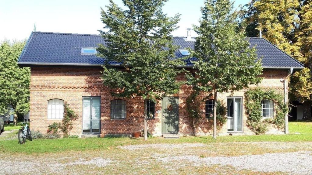 une maison en briques avec un toit bleu dans l'établissement Große Wohnung in Curau mit Terrasse, Garten und Grill, à Stockelsdorf