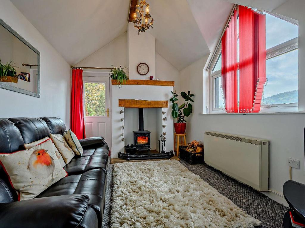 a living room with a leather couch and a fireplace at 1 Bed in Troutbeck nr Ullswater SZ254 in Troutbeck