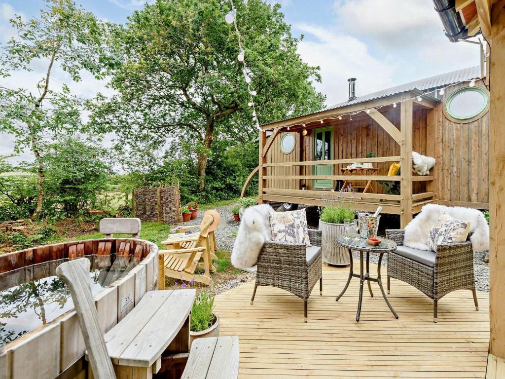 una terraza con sillas, una mesa y una casa en 1 Bed in Great Torrington 82862, en Sheepwash
