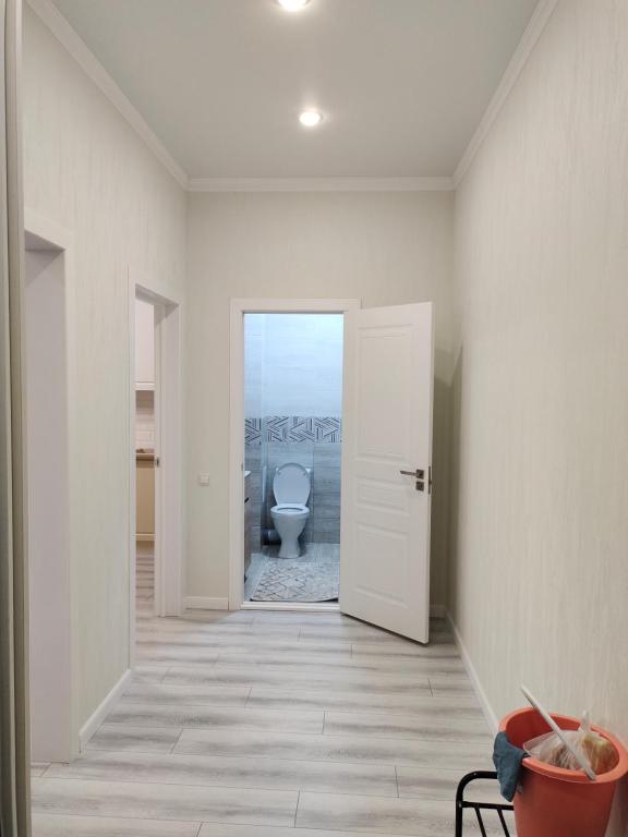 a hallway with a toilet in a white room at ЖК Брюссель in Taldykolʼ