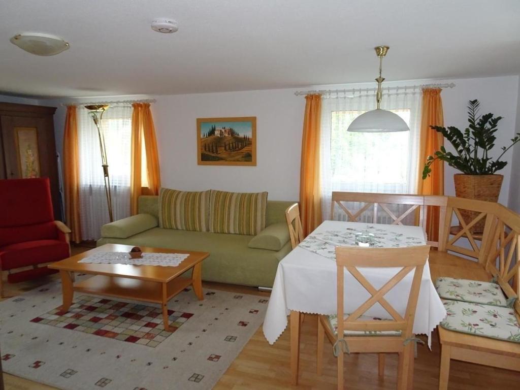 a living room with a green couch and a table at Nette Wohnung in Garitz mit Garten, Terrasse und Grill in Bad Kissingen