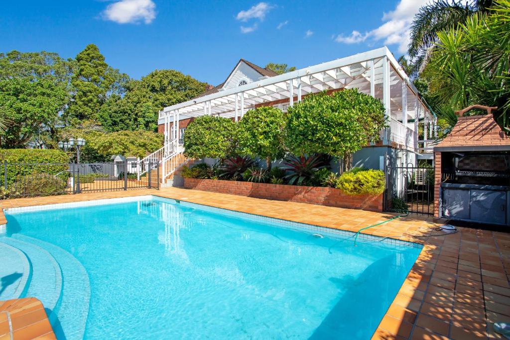 a swimming pool in front of a house at Grande Vista 5Br Manor with Pool & Mt Eden Views in Auckland