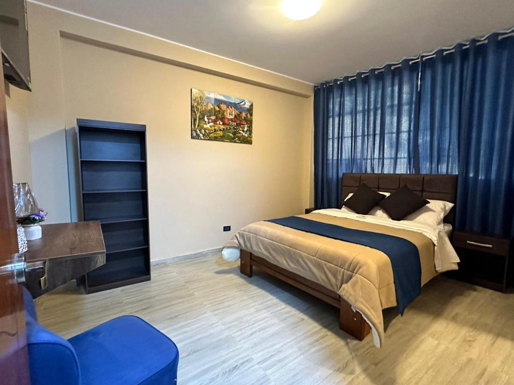 1 dormitorio con 1 cama y 1 silla azul en Gran Hotel, en Yungay