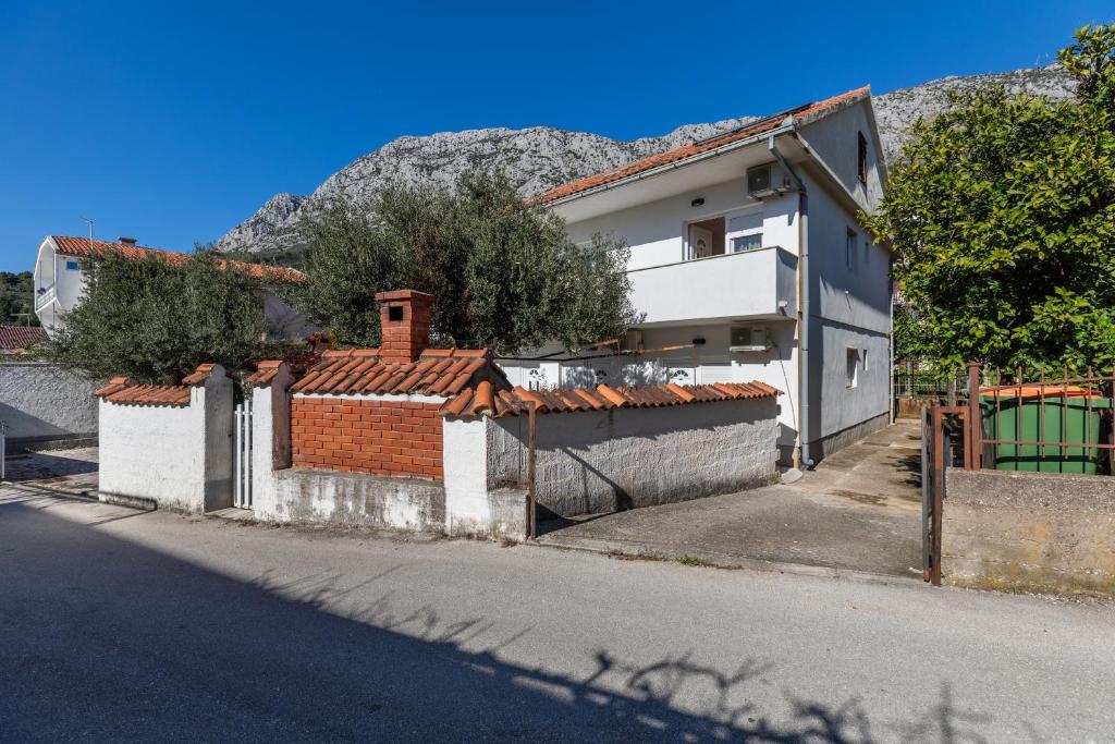 a house with a fence next to a street at Apartments with a parking space Podaca, Makarska - 6050 in Podaca