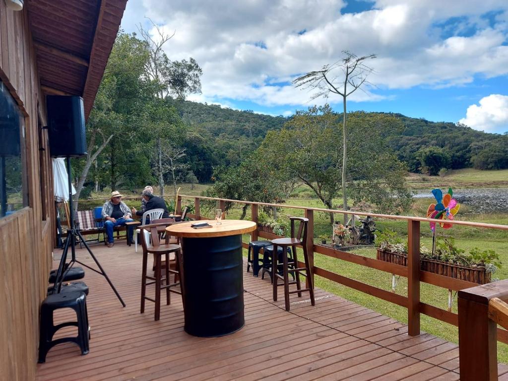 a wooden deck with a table and chairs on it at Fazenda Serramar in Palhoça