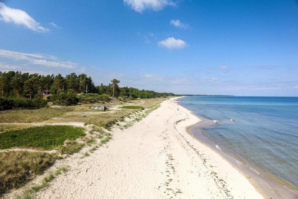 a view of a sandy beach next to the ocean at Ferienhaus in Yngsjö wenige Schritte zum Meer in Yngsjö