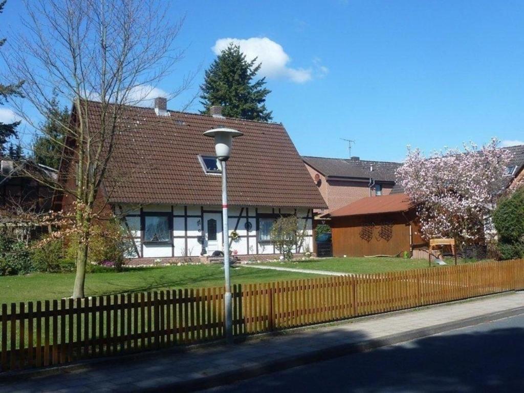 uma casa com uma cerca e uma luz de rua em Große Ferienwohnung in Bad Fallingbostel mit Garten, Grill und Terrasse em Bad Fallingbostel