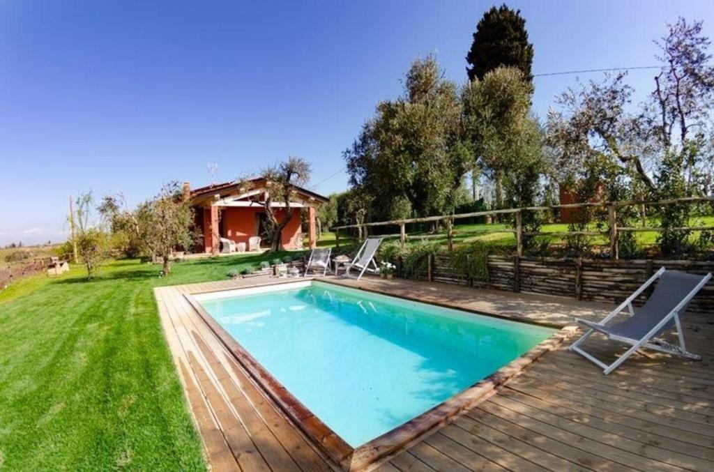 uma piscina com duas espreguiçadeiras e uma casa em Ferienhaus mit Privatpool für 4 Personen ca 55 qm in Aiale, Toskana Provinz Pisa em Lari