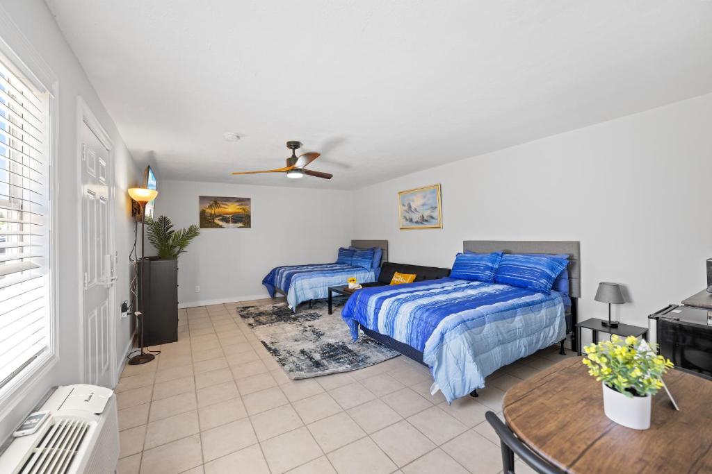 um quarto com 2 camas e uma mesa em 2 Bed Cottage with Pool, Close to Beach! BBQ Grills & Patio em Fort Myers