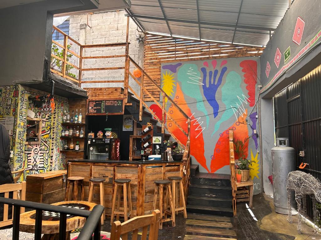 a restaurant with a bar with a colorful mural at Casa Satoshi in San Cristóbal de Las Casas