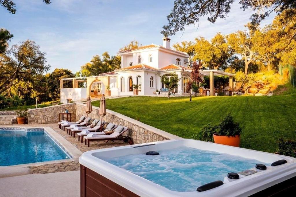 una bañera de hidromasaje al aire libre frente a una casa en Traumhaftes Ferienhaus mit privatem Pool und Tennisplatz im Herzen Andalusiens, en Alhama de Granada