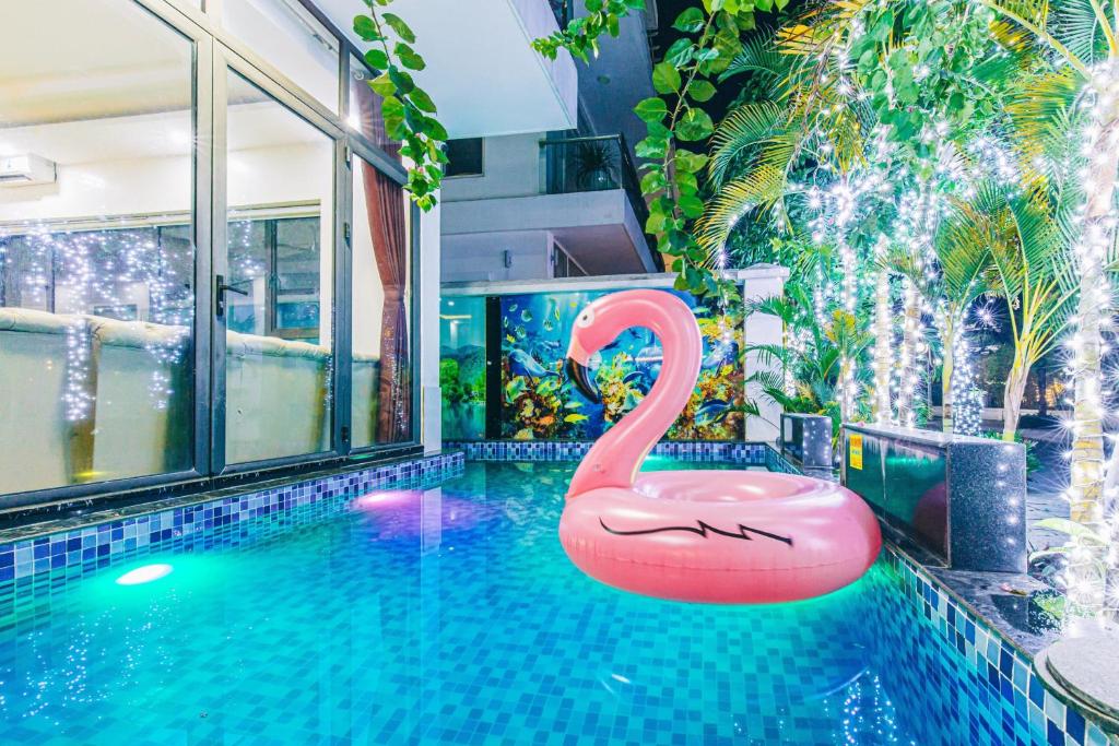 uma piscina com um cisne cor-de-rosa no meio em VILLA SB123 FLC SẦM SƠN em Sam Son