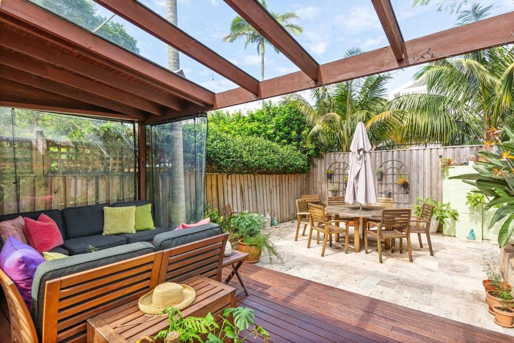eine Terrasse mit einem Sofa und einem Tisch in der Unterkunft Heritage Charm in Manly's Sun-Drenched Paradise in Sydney