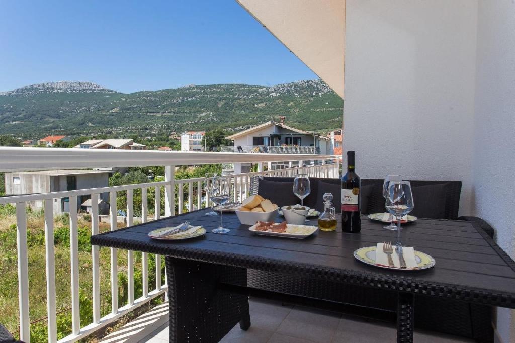 een zwarte tafel met wijnglazen en eten op een balkon bij Ferienwohnung für 5 Personen ca 75 qm in Kaštel Lukšić, Dalmatien Kaštela und Umgebung - b56258 in Kaštela