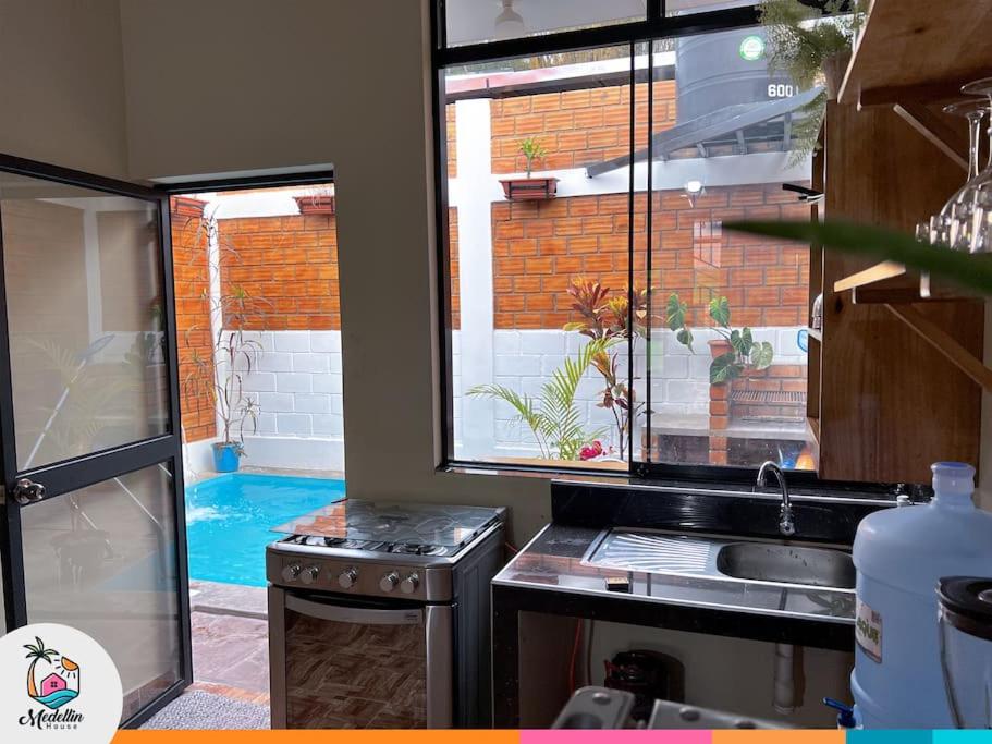 uma cozinha com um lavatório e vista para uma piscina em Acogedor Suite en Moyobamba - Medellín House I em Moyobamba