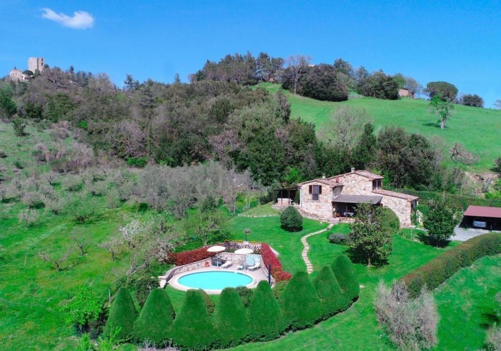 una vista aerea di una casa in un campo verde di Private toskanische Villa mit Pool und Whirlpool in der Nähe von Siena a San Dalmazio