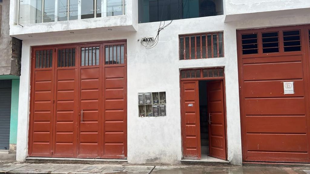 zwei rote Türen an der Seite eines Gebäudes in der Unterkunft Mini apartamento en Ayacucho in Ayacucho