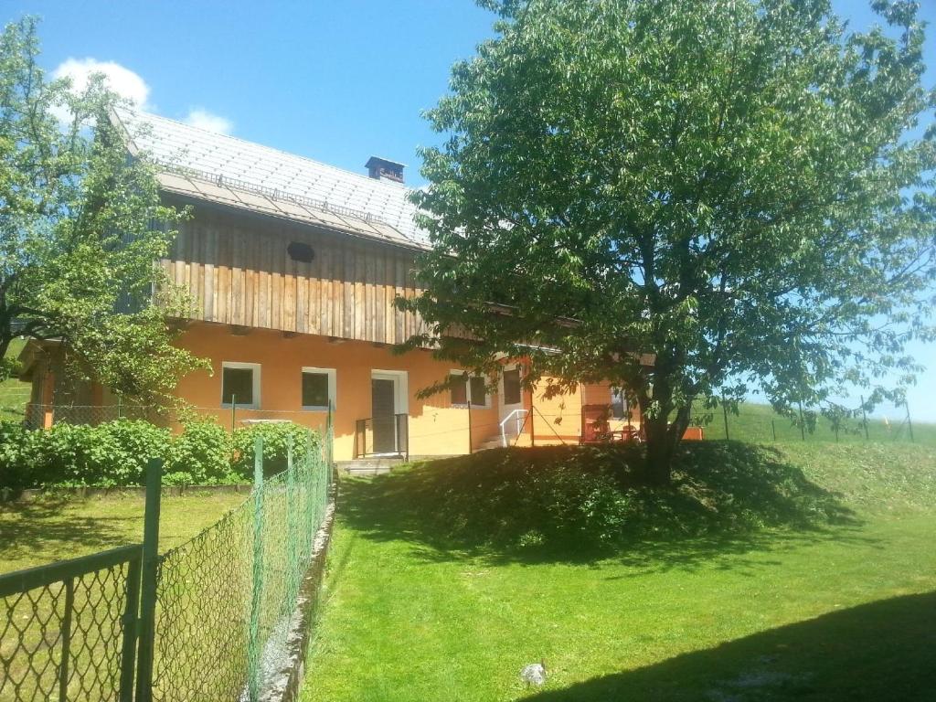 a house with a tree and a fence at Modernes Ferienhaus in bergiger Lage nahe Kärntner Seelandschaft 