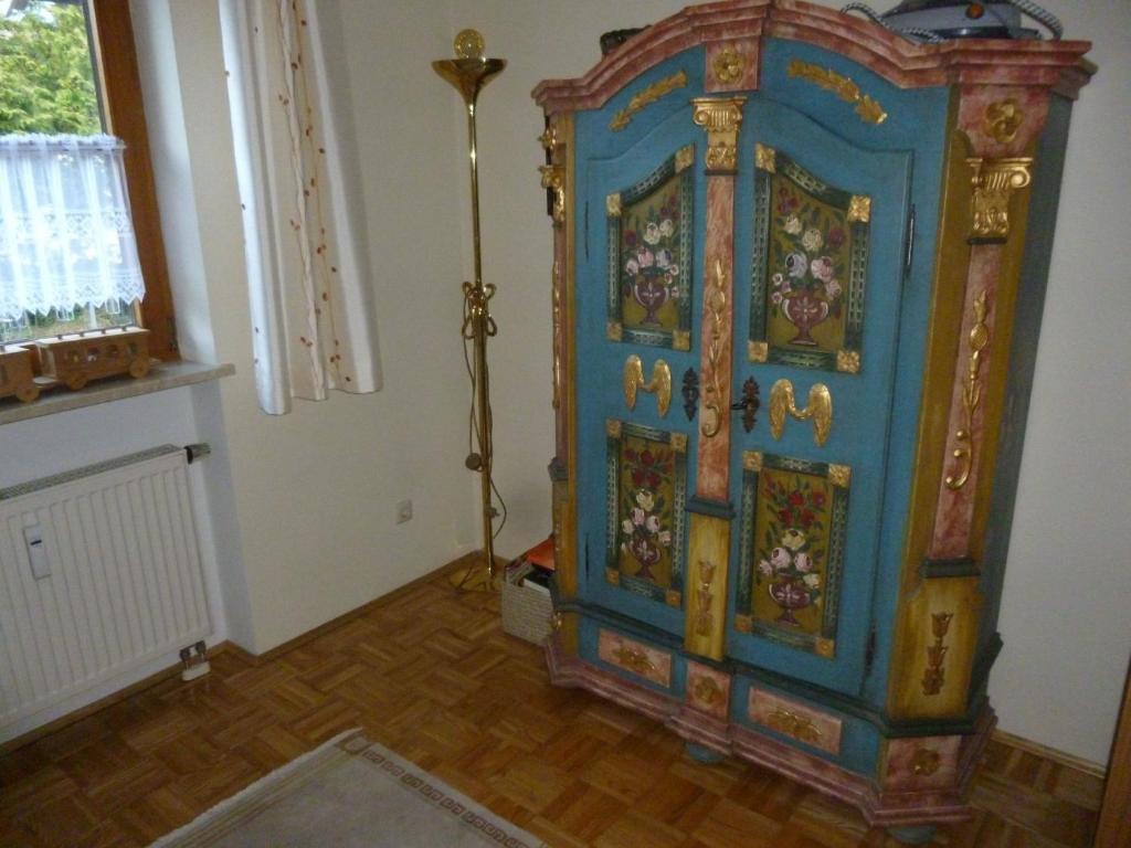 a large colorful cabinet in a room with a window at Wohnung in Pidingerau mit Großer Terrasse in Piding