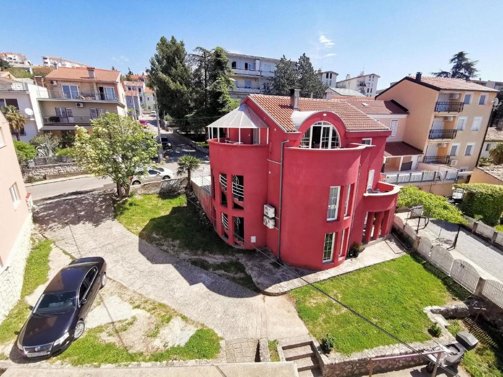 ein rotes Haus mit einem davor geparkt in der Unterkunft Studio für 5 Personen ca 70 qm in Crikvenica, Kvarner Bucht Crikvenica und Umgebung in Crikvenica