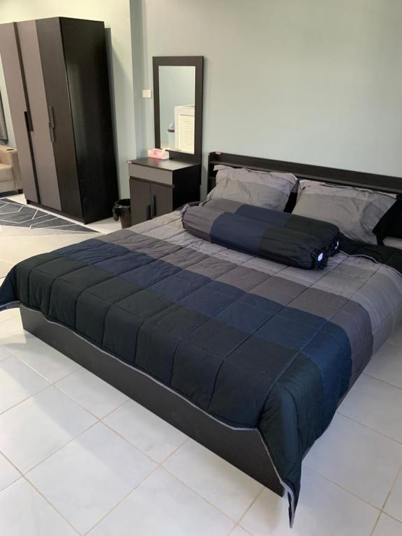 - un grand lit avec une couette bleue dans une chambre dans l'établissement Fullmoon Jomtien Guest house, à Jomtien Beach