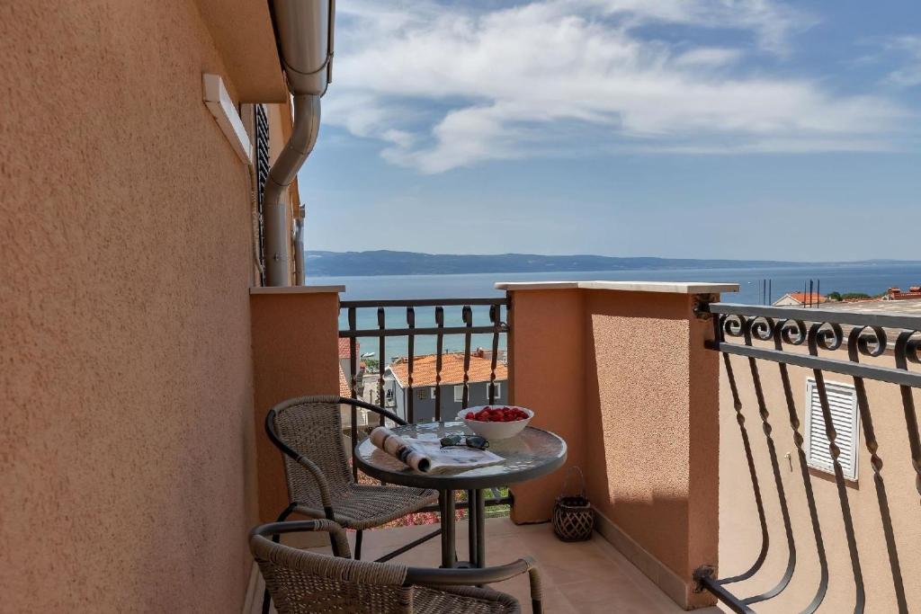 einen Balkon mit einem Tisch und Stühlen sowie Meerblick in der Unterkunft Gästezimmer für zwei Personen mit Balkon in Duće