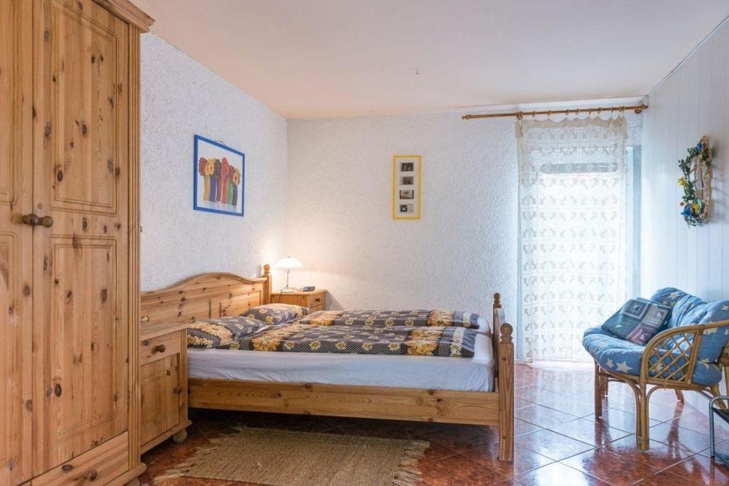 1 dormitorio con 1 cama, 1 silla y 1 ventana en Gästezimmer mit Terrasse, en Zehdenick