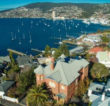 uma vista aérea de uma casa e um porto com barcos em Grande Vue em Hobart