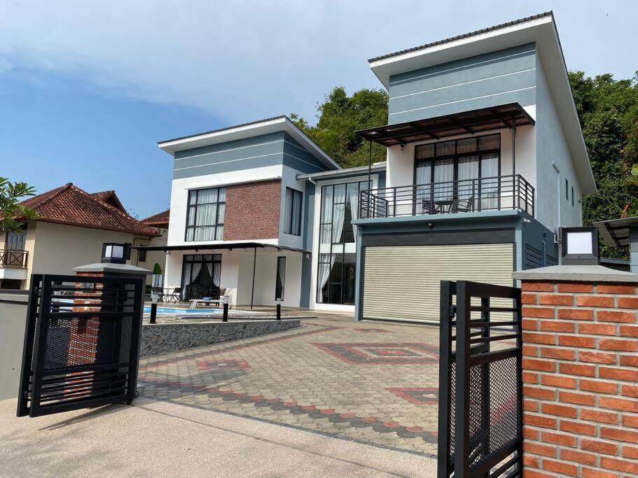 a house with a gate in front of it at Casa al Mare Andaman Hills Villa in Pantai Cenang