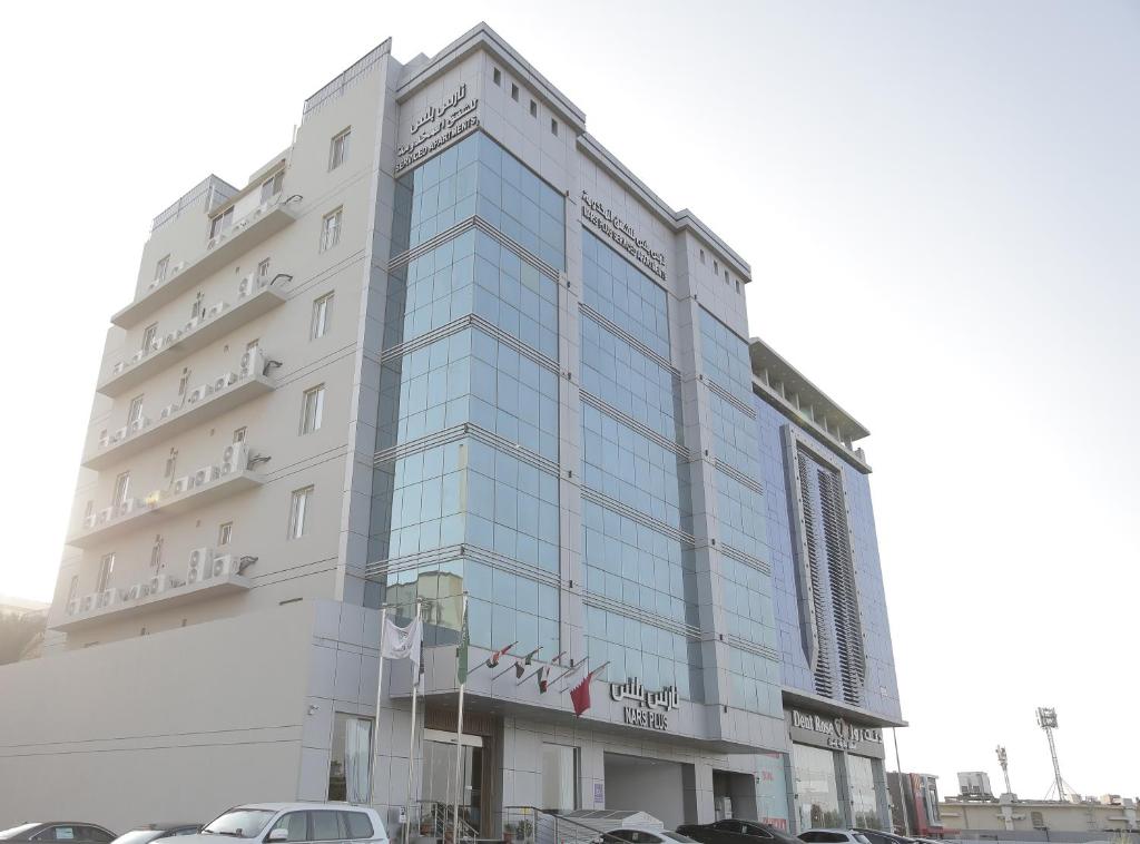 a large building with cars parked in front of it at فندق نارس بلس البساتين - Nars Plus Hotel in Jeddah