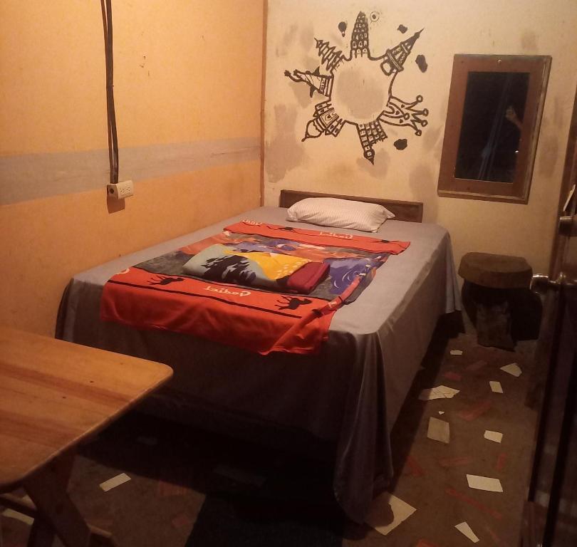 a small bed in a room with a table at coraizone hostel in Cobán