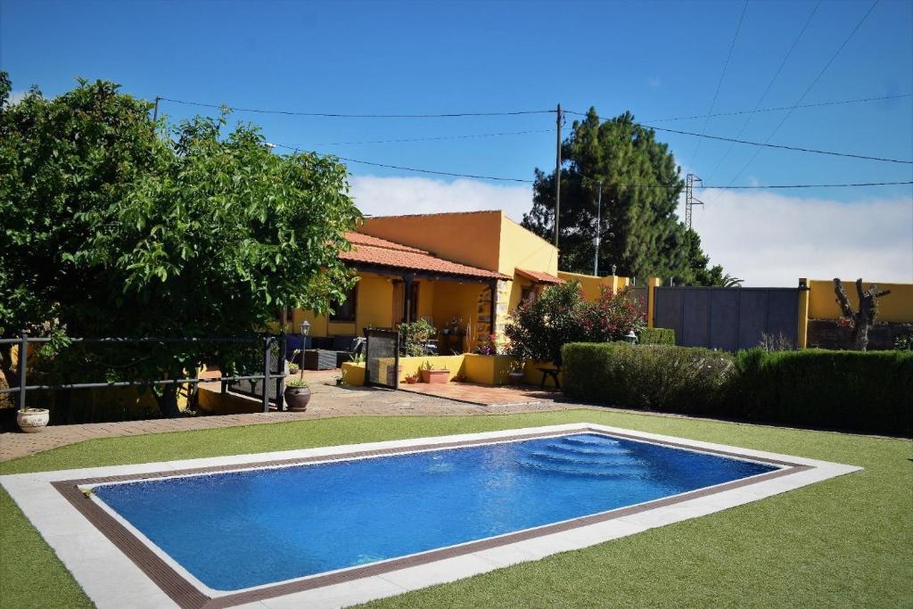 a swimming pool in the yard of a house at Gemütliches Ferienhaus in El Rosario mit Privatem Pool und Panoramablick in El Rosario