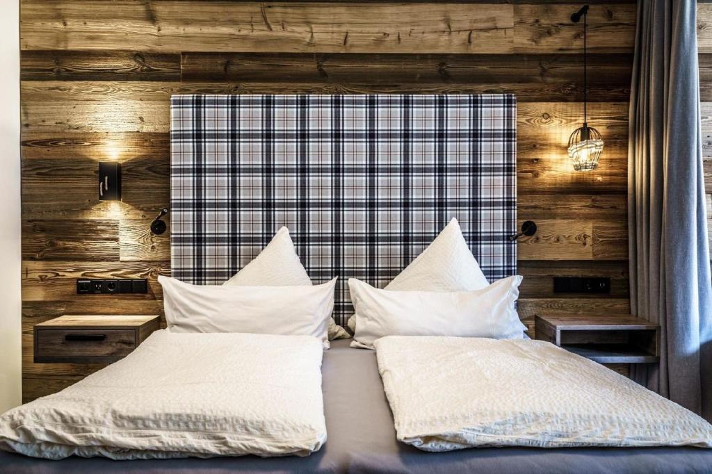 1 dormitorio con 1 cama con sábanas y almohadas blancas en Ferienwohnungen direkt an der Skiabfahrt und MTB-Trails - b56870 en Sölden