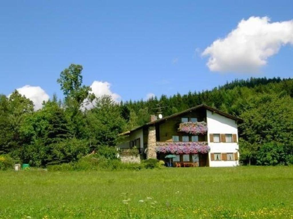 a house in a field with a green field at Ferienwohnung in Schlag mit großer Terrasse - b57148 in Kirchdorf im Wald