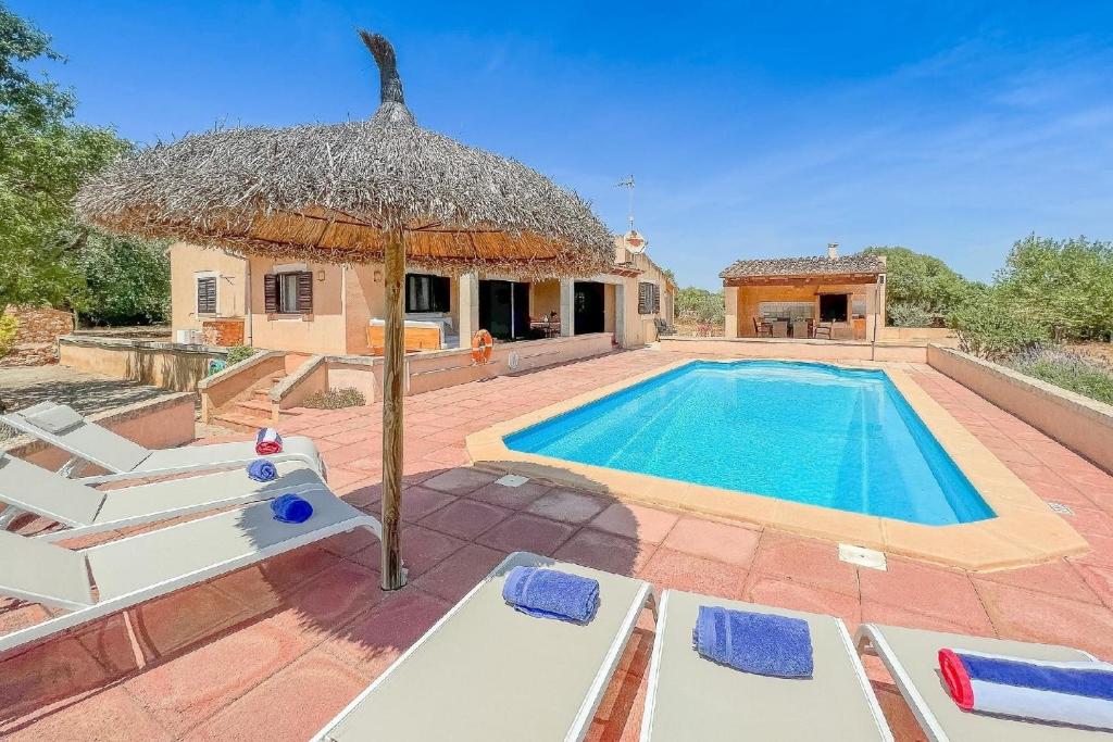 an outdoor swimming pool with chairs and an umbrella at Ferienhaus mit Privatpool für 6 Personen ca 120 qm in Campos, Mallorca Südküste von Mallorca in Campos