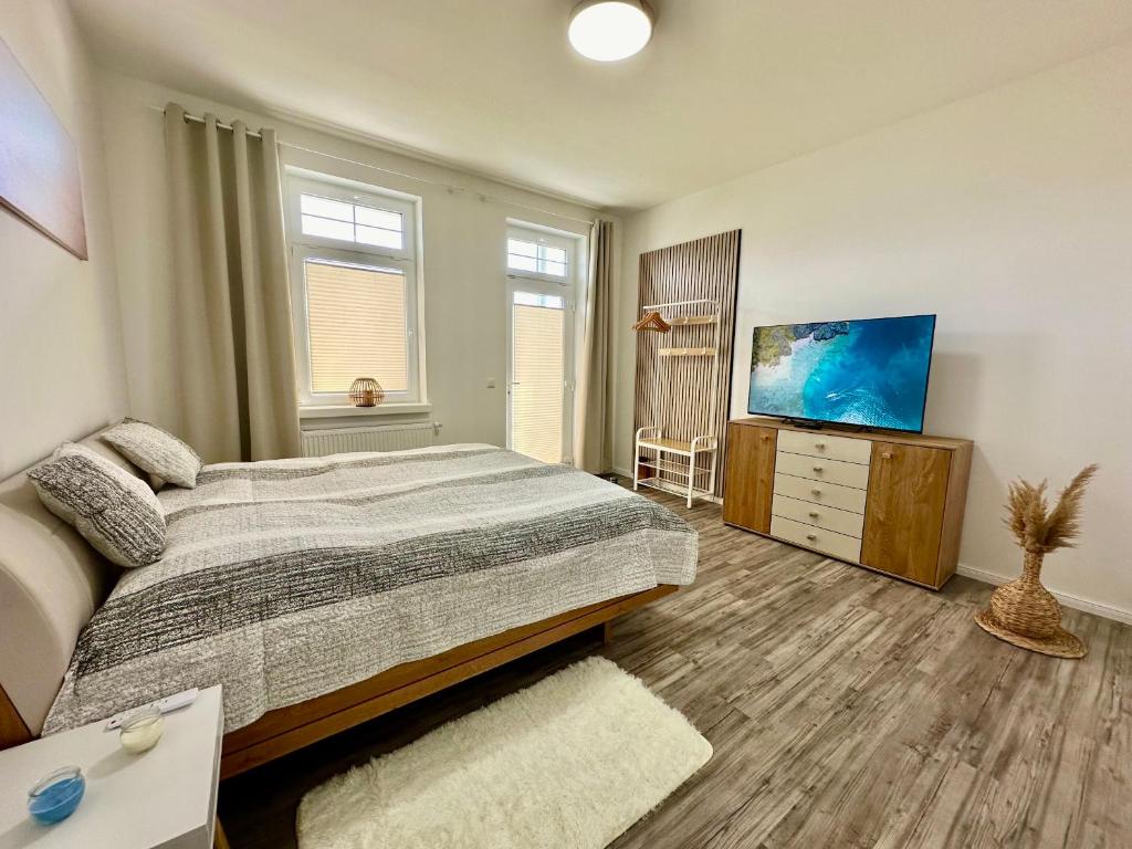 una camera da letto con un letto e una TV a schermo piatto di Haus Concordia 2 Wellenreiter a Thiessow