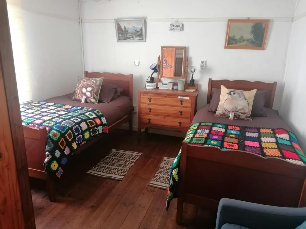 1 dormitorio con 2 camas y vestidor en Kate's Country Kitchen Accommodation, en Bredasdorp