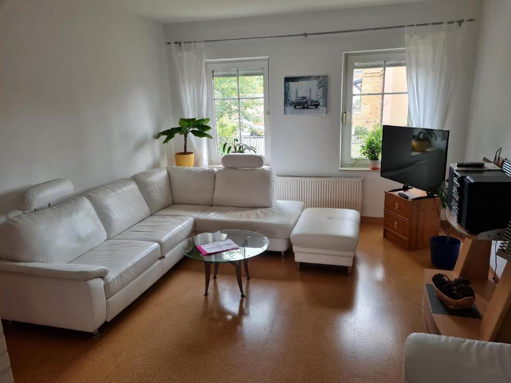 een woonkamer met een witte bank en een tv bij Appartement in WeißwasserOberlausitz mit Großem Garten in Weißwasser