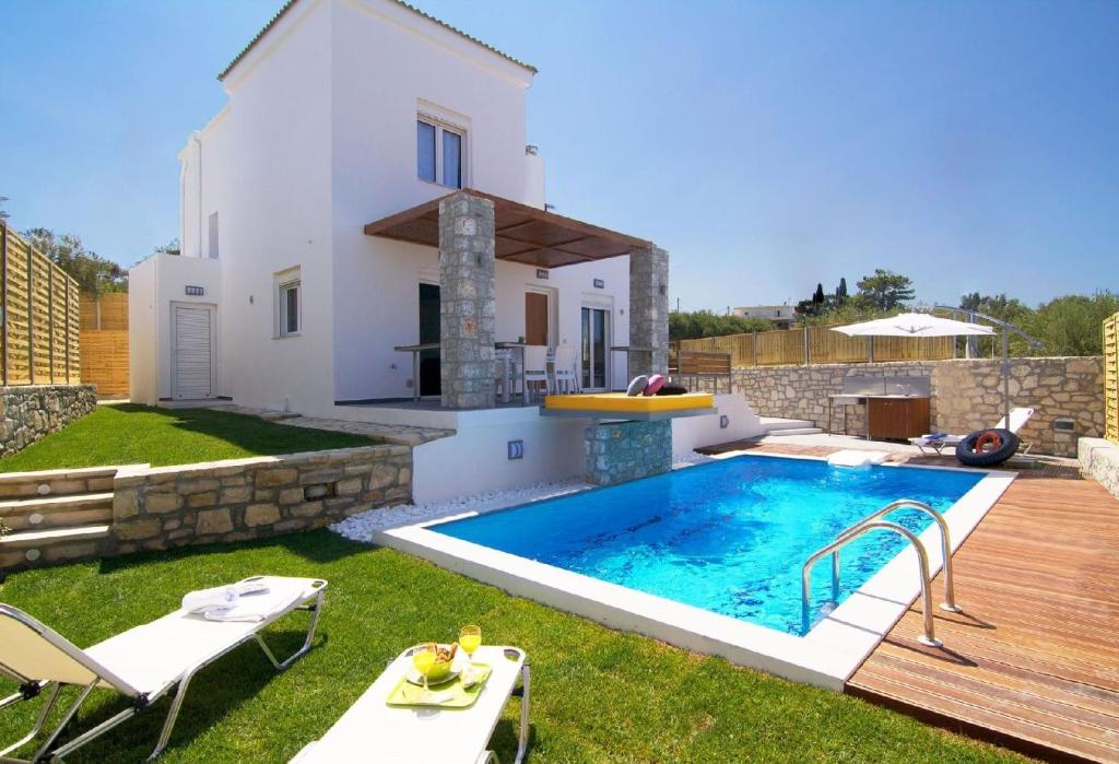 a backyard with a swimming pool and a house at Villa Alexandra - Komfort mit eigenem Pool in Loutra