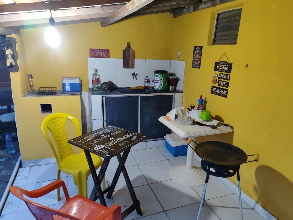 a kitchen with yellow walls and a table and chairs at Casa do Edi in Bananeiras