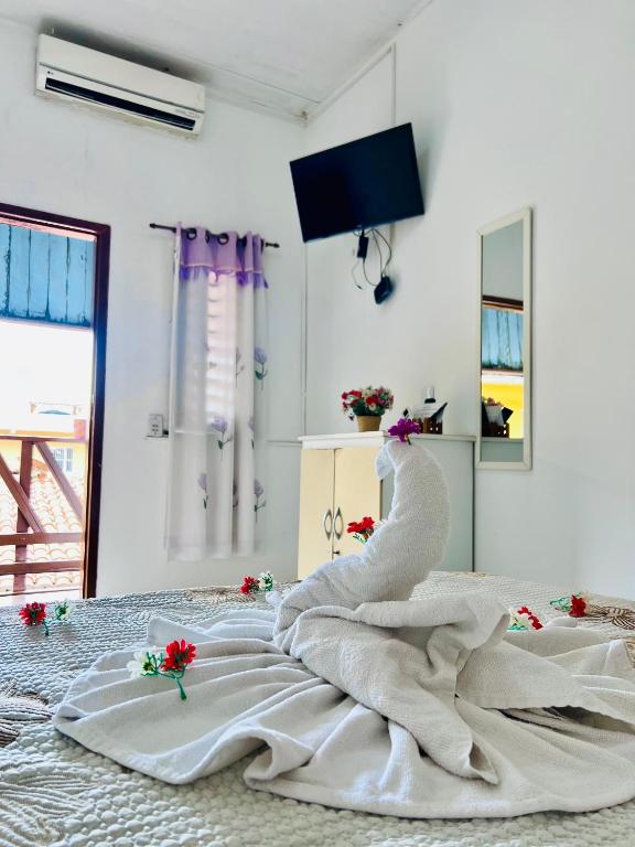 ein weißes Bett mit einem weißen Handtuch drauf in der Unterkunft Pousada Cafe e Mar Jeri in Jericoacoara