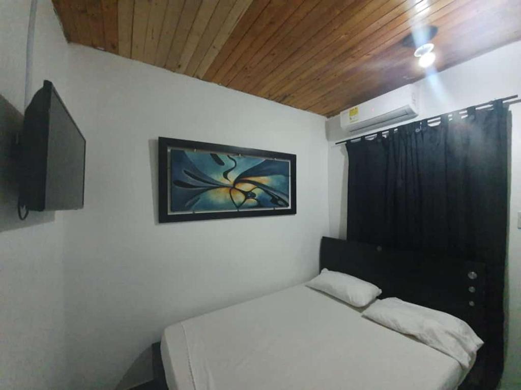 ein kleines Schlafzimmer mit einem Bett und einem Fenster in der Unterkunft El rancho de arnolis in Cereté