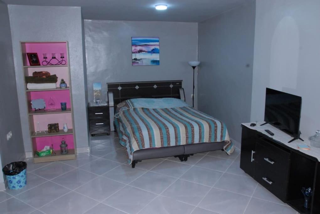 a bedroom with a bed and a flat screen tv at Élégant Studio in Meknès
