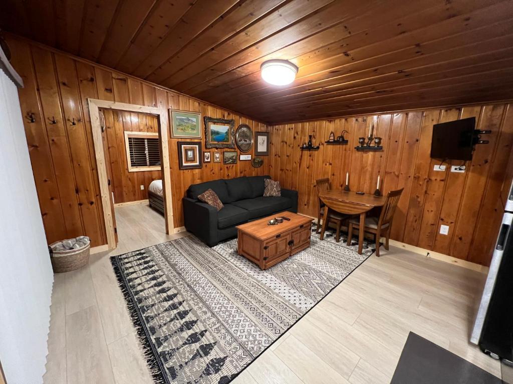 a living room with a couch and a table at Rustic 1 bd 1 ba Cabin at New Waitts Lake Resort in Valley