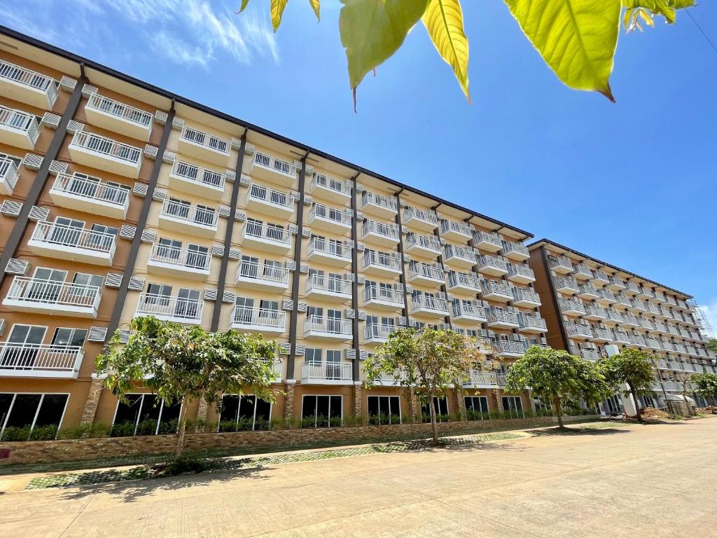 duży budynek z drzewami przed nim w obiekcie Palawan Paradise Condotel 6F w mieście Puerto Princesa