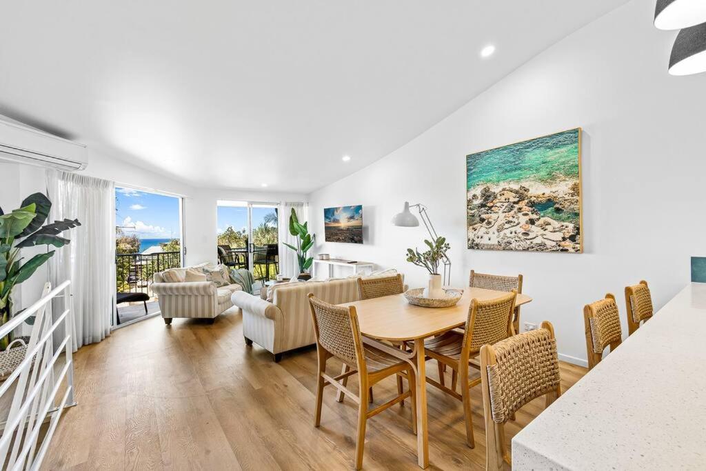 a dining room and living room with a table and chairs at 3 Andari Sunshine Beach Modern Apt 1 Min Beach in Sunshine Beach